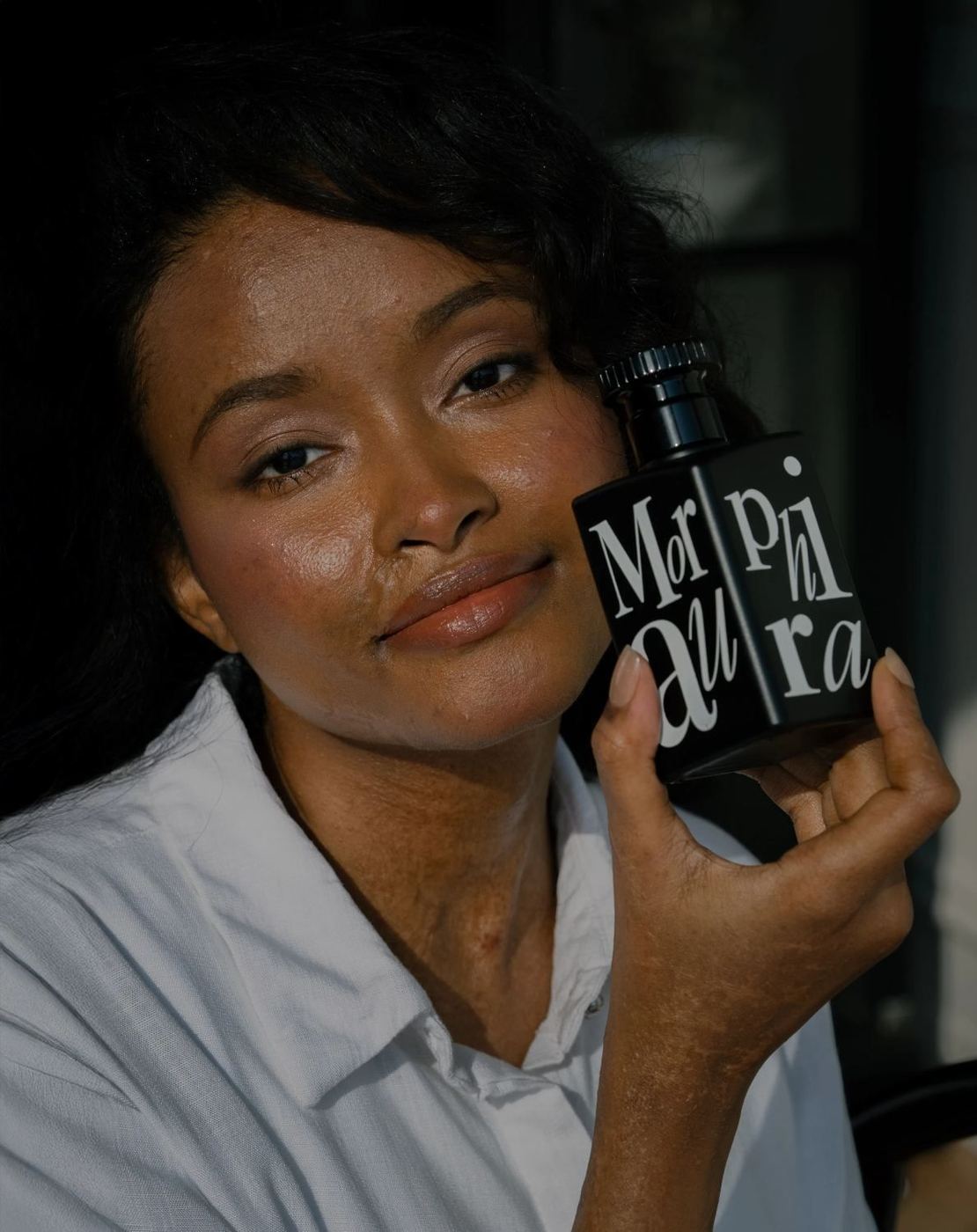 A woman holding MorphiK Aura to her cheek